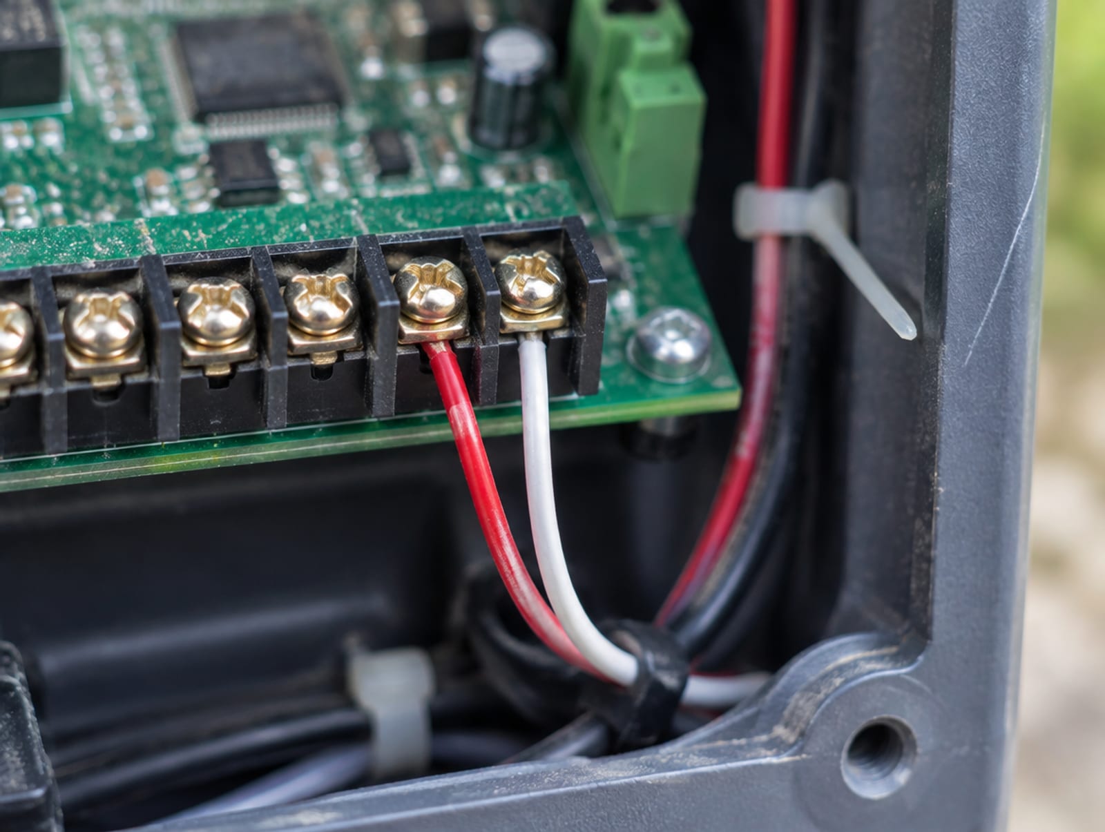 Gate operator control board with two low-voltage wires landed on the access input terminals