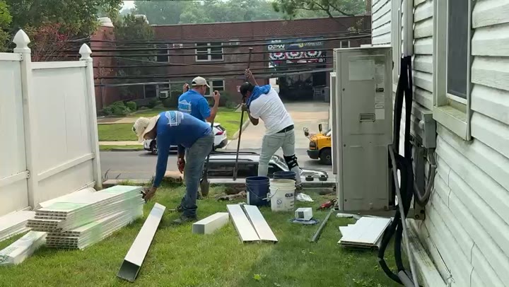 Installing a white vinyl fence along a village street