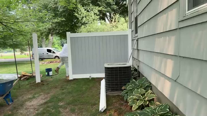 Installing a vinyl privacy fence panel beside the house